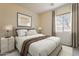 Neutral-toned bedroom with a comfortable bed, soft lighting, and a view from the window at 30374 N 124Th Dr, Peoria, AZ 85383