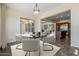 Dining room with modern chandelier, neutral paint, view into the living room, and plenty of light at 30374 N 124Th Dr, Peoria, AZ 85383