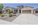 Charming home featuring a tile roof, desert landscaping, and a wide driveway leading to a two-car garage at 30374 N 124Th Dr, Peoria, AZ 85383