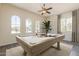 Bright game room features a stylish billiard table beneath a ceiling fan and three arched windows at 30374 N 124Th Dr, Peoria, AZ 85383