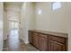 Hallway leading to the living area, featuring built-in cabinets and natural light from windows at 30374 N 124Th Dr, Peoria, AZ 85383