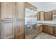 Bright kitchen featuring stainless refrigerator and abundant wood cabinets and granite counters at 30374 N 124Th Dr, Peoria, AZ 85383