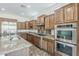 Kitchen boasts stainless steel appliances, granite countertops, tile floors, gas range, and double ovens at 30374 N 124Th Dr, Peoria, AZ 85383