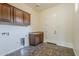 Functional laundry room with overhead cabinets, tile flooring, and a utility sink at 30374 N 124Th Dr, Peoria, AZ 85383