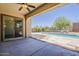 Covered patio overlooking a pristine swimming pool and meticulously landscaped backyard at 30374 N 124Th Dr, Peoria, AZ 85383