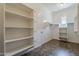 Spacious walk-in closet boasts ample shelving, a hanging rod, and stylish tile flooring at 30374 N 124Th Dr, Peoria, AZ 85383