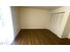 Bright bedroom featuring wood-look flooring and a closet with folding doors at 3404 W Tangerine Ln, Phoenix, AZ 85051