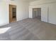 Large bedroom featuring neutral carpet, multiple doors, and access to closets at 3407 N 67Th Ln, Phoenix, AZ 85033