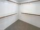 Walk-in closet featuring carpet, white walls, and wooden shelves for storage at 3407 N 67Th Ln, Phoenix, AZ 85033