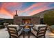 Backyard patio with stone fireplace, comfortable lounge seating, and desert landscape in the background at 36133 N 24Th Ave, Phoenix, AZ 85086