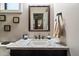 Elegant powder room featuring a marble countertop, white sink and vanity with black hardware at 36133 N 24Th Ave, Phoenix, AZ 85086