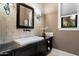 Modern bathroom with decorative wall, stylish mirror, stone countertop, and under-cabinet storage at 36133 N 24Th Ave, Phoenix, AZ 85086