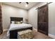 Cozy bedroom with a dark wood bed frame, decorative pillows, and a sliding barn door for added charm at 36133 N 24Th Ave, Phoenix, AZ 85086