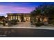 Exterior of a luxury home at dusk with a circular driveway, stone accents, and desert landscaping at 36133 N 24Th Ave, Phoenix, AZ 85086