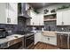 Modern kitchen with stainless steel appliances, white cabinets, granite countertops and brick backsplash at 36133 N 24Th Ave, Phoenix, AZ 85086