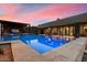 Sparkling pool illuminated with underwater lights, surrounded by travertine decking and desert landscaping at 36133 N 24Th Ave, Phoenix, AZ 85086