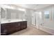 Bright bathroom featuring double vanity, walk-in shower, soaking tub, and neutral tile flooring at 3822 E Amber Ln, Gilbert, AZ 85296