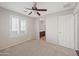 A bright bedroom featuring a ceiling fan, large window, and an ensuite bathroom at 3822 E Amber Ln, Gilbert, AZ 85296