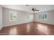 Spacious living room featuring hardwood floors, a ceiling fan, and large shuttered windows at 3822 E Amber Ln, Gilbert, AZ 85296