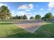 Community sand volleyball court surrounded by green lawns and mature trees at 3822 E Amber Ln, Gilbert, AZ 85296