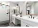 Modern bathroom with dual sinks, sleek white cabinets, and a glass-enclosed shower at 3938 E Appaloosa Rd, Gilbert, AZ 85296