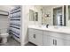 Clean bathroom with dual sinks, white cabinets, and a stylish, striped shower curtain at 3938 E Appaloosa Rd, Gilbert, AZ 85296