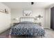 Bright bedroom featuring a floral bedspread, soft gray walls, and stylish wall decor at 3938 E Appaloosa Rd, Gilbert, AZ 85296