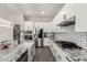 Open kitchen features granite countertops, white cabinetry, stainless steel appliances, and a breakfast bar at 3938 E Appaloosa Rd, Gilbert, AZ 85296