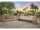 Elegant property featuring a brick driveway and gate entrance, surrounded by beautiful mature landscaping at 4836 E Moonlight Way, Paradise Valley, AZ 85253