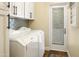 Laundry room featuring white cabinets, tile backsplash, and door at 4836 E Moonlight Way, Paradise Valley, AZ 85253