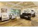 Bright living room featuring hardwood floors, comfortable seating, and a wet bar with modern cabinetry at 4836 E Moonlight Way, Paradise Valley, AZ 85253
