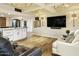 Inviting living room featuring a wet bar with white cabinetry, hardwood floors and comfortable seating at 4836 E Moonlight Way, Paradise Valley, AZ 85253