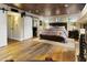 Bedroom featuring a stone fireplace, king bed, and wood-look floors at 4836 E Moonlight Way, Paradise Valley, AZ 85253