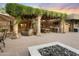 Expansive outdoor space with a fire pit, lounge area, outdoor kitchen, and a pergola at 4836 E Moonlight Way, Paradise Valley, AZ 85253