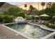 Beautiful pool area with comfortable lounge chairs, lush greenery, and mountain views at sunset at 4836 E Moonlight Way, Paradise Valley, AZ 85253