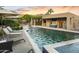 Luxurious backyard featuring a sparkling pool, lounge chairs, outdoor umbrellas, and desert landscape at 4836 E Moonlight Way, Paradise Valley, AZ 85253