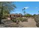 Expansive backyard featuring desert landscaping, fountain, mature trees and covered patio at 5728 E Sharon Dr, Scottsdale, AZ 85254