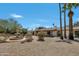 Spacious backyard featuring a water fountain, desert landscaping, and palm trees at 5728 E Sharon Dr, Scottsdale, AZ 85254