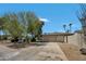 Single-story home with a multi-car garage, mature trees and desert landscaping at 5728 E Sharon Dr, Scottsdale, AZ 85254