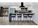 Modern kitchen features white cabinets, stainless steel appliances, black countertops, and bar stool seating at 5728 E Sharon Dr, Scottsdale, AZ 85254