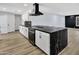 Modern kitchen with white cabinets, black countertops, stainless steel appliances and a black exhaust hood at 5728 E Sharon Dr, Scottsdale, AZ 85254