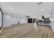 Large living room with wood flooring, fireplace, and open access to the modern kitchen at 5728 E Sharon Dr, Scottsdale, AZ 85254