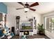 Bright living room with wood floors, entertainment center with fireplace, and modern ceiling fan at 6160 S Pebble Beach Dr, Chandler, AZ 85249