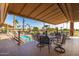 Relaxing outdoor patio with dining tables overlooking the lush golf course and community pool at 6160 S Pebble Beach Dr, Chandler, AZ 85249