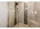 Elegant tiled walk-in shower with mosaic accent and rainfall shower head at 6160 S Pebble Beach Dr, Chandler, AZ 85249