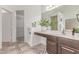 Bright bathroom features stone tile floors, a vanity with white sink, and a walk-in closet at 725 S Canfield --, Mesa, AZ 85208