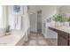 Bright bathroom with dual sinks, decorative tile flooring, and a separate tub at 725 S Canfield --, Mesa, AZ 85208
