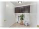 Well-lit laundry room features upper cabinets, tile flooring and a plant for a fresh, clean laundry experience at 725 S Canfield --, Mesa, AZ 85208