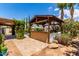 Outdoor kitchen with built-in BBQ grill, bar area with umbrella, and a swimming pool at 725 S Canfield --, Mesa, AZ 85208