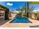 Backyard oasis with a sparkling pool, lush landscaping, mature trees, and travertine tile decking at 725 S Canfield --, Mesa, AZ 85208